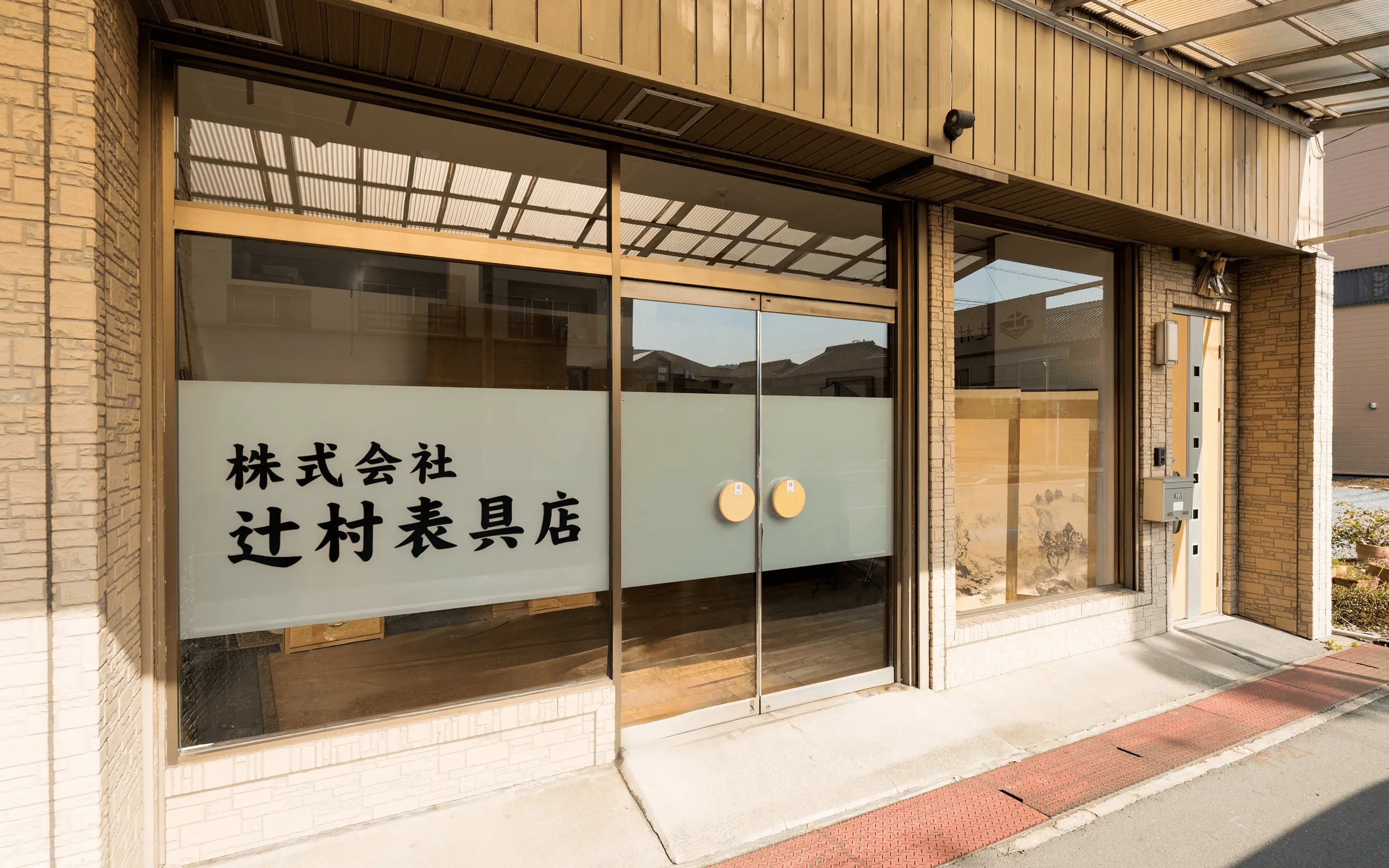 株式会社辻村表具店（店舗外観のガラス扉に記載されている文字）