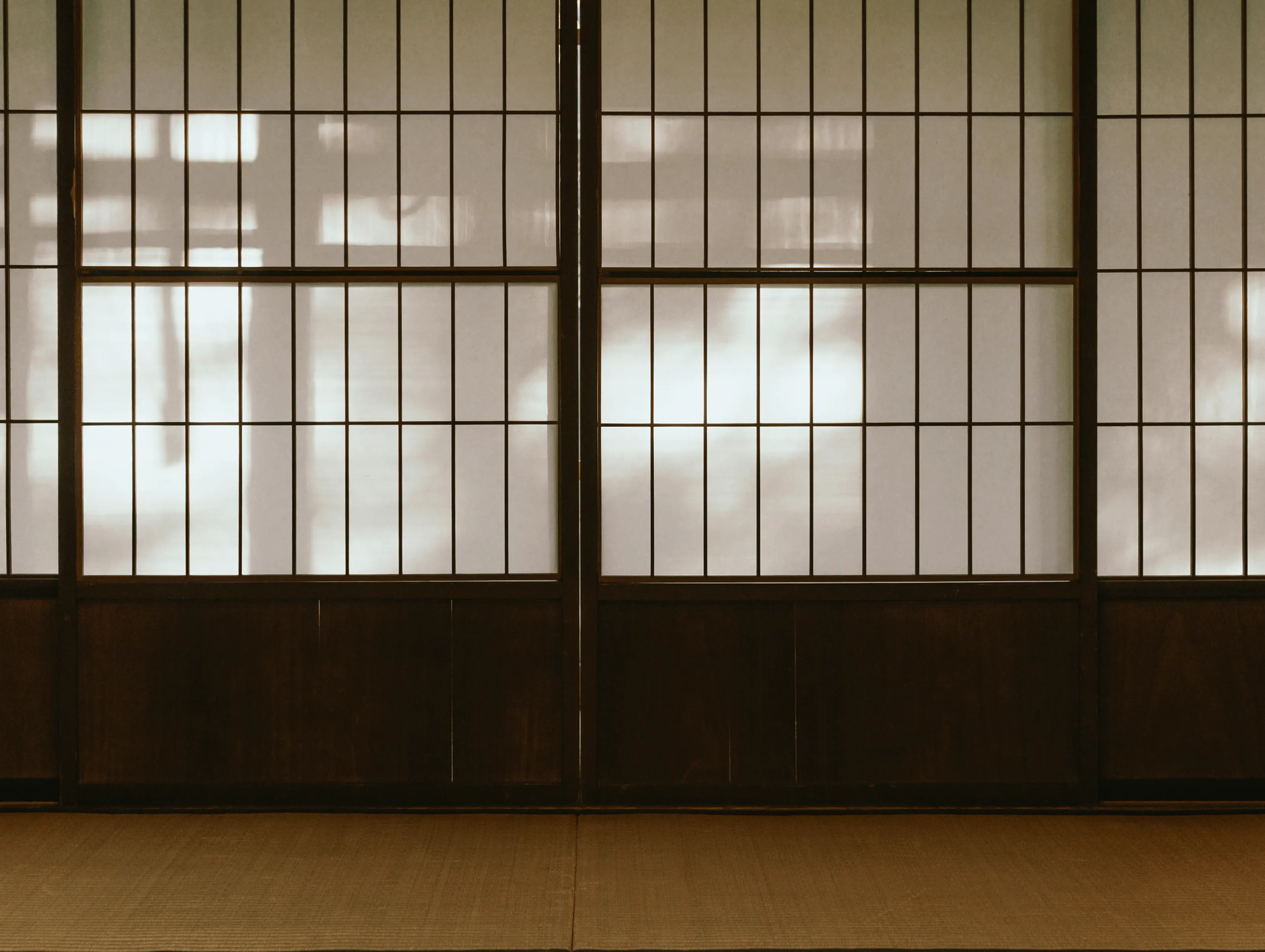 障子越しに柔らかな外光が入る和室の室内風景。均等に組まれた障子桟と和紙の質感が分かり、日本家屋の採光設計や障子張替え・建具修理による快適な住環境づくりを伝える。